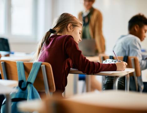 Younger Girl Taking Notes at Desk
